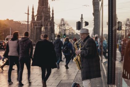 street musician playing saxophone outside a busy area in edinburgh